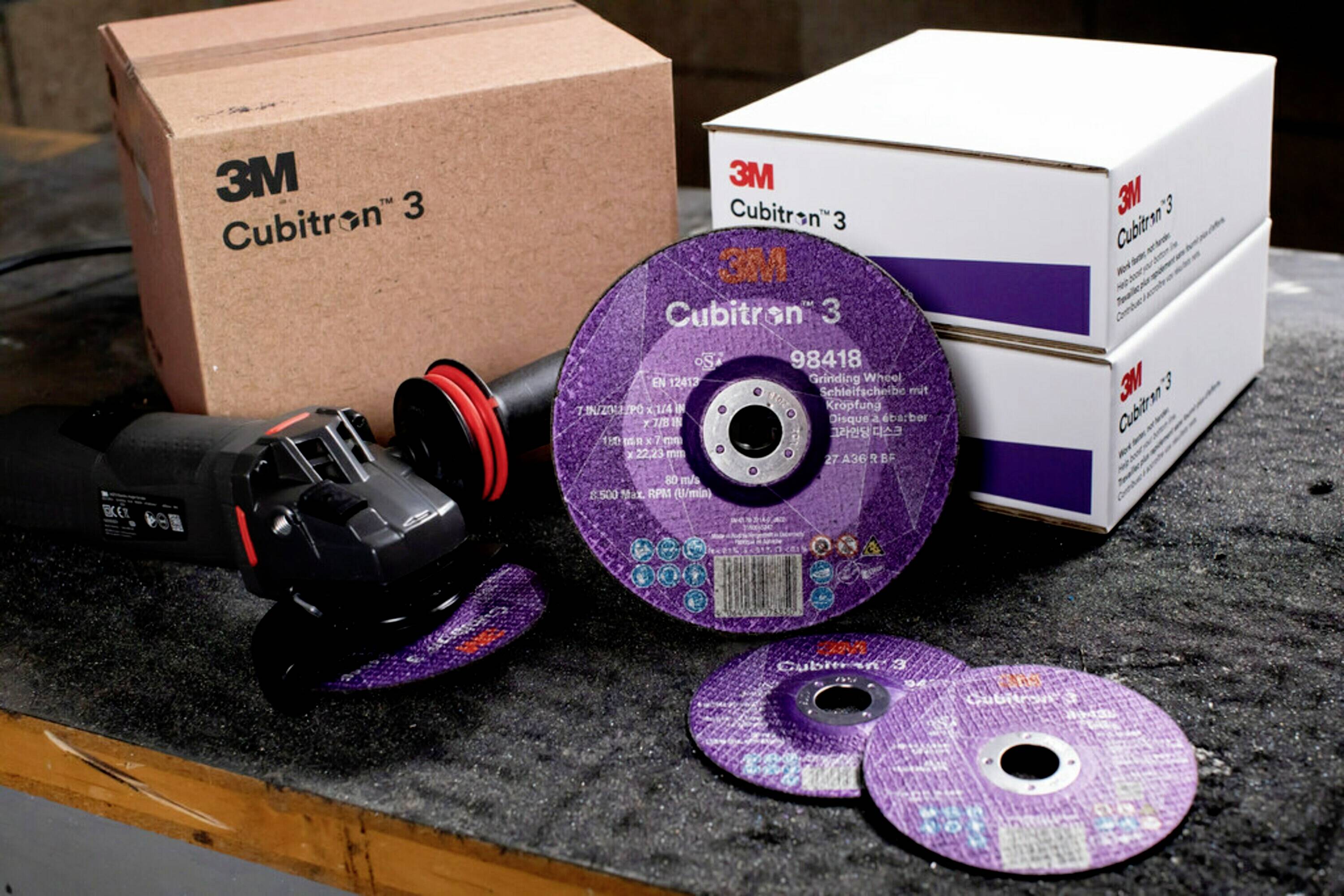 Slipmaskinstillbehör från 3M Cubitron, tre stycken liggande på en arbetsbank, två förpackade i kartonger, med ett slipverktyg bredvid.