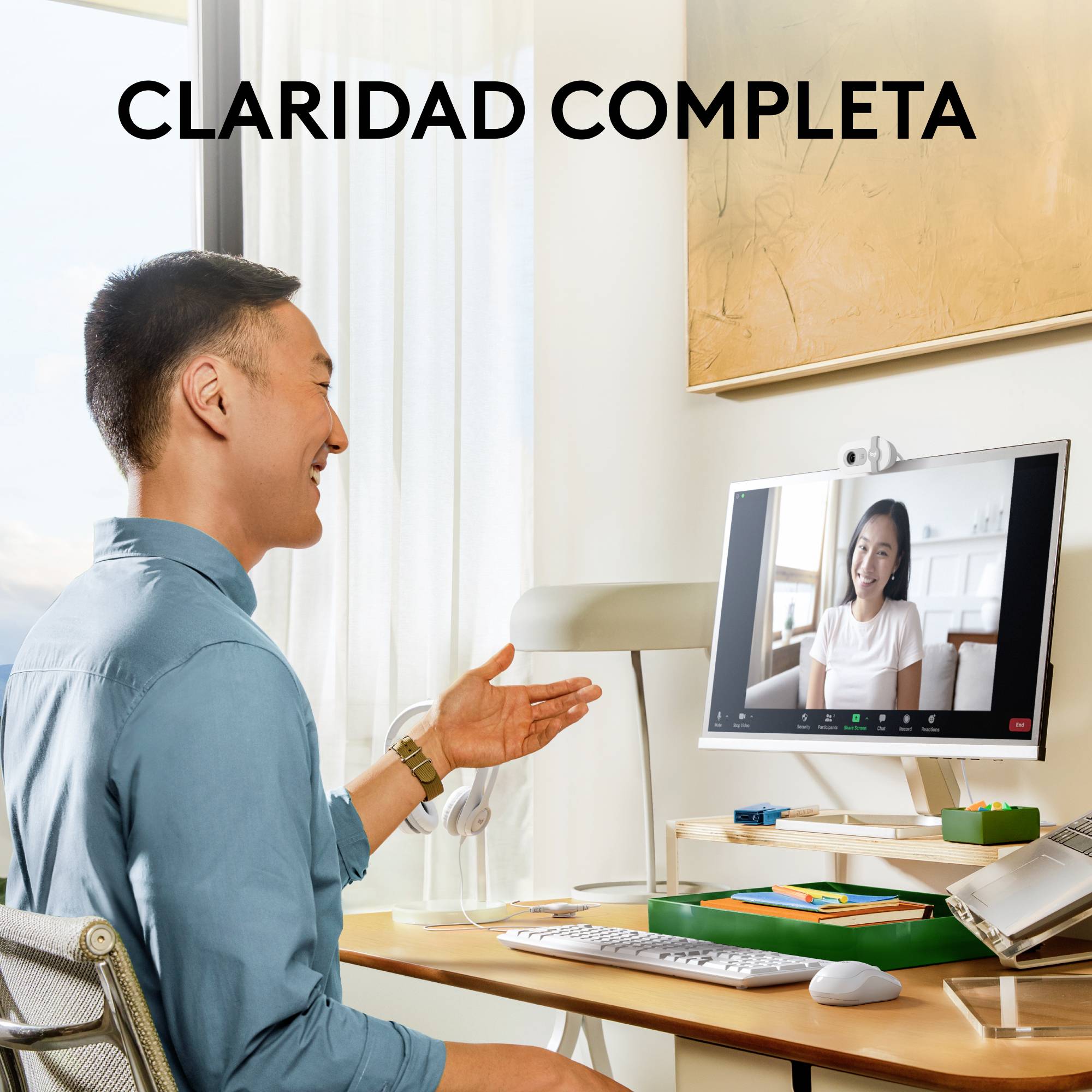 En person sitter vid ett skrivbord och deltar i ett videosamtal med en annan person på en datorskärm.