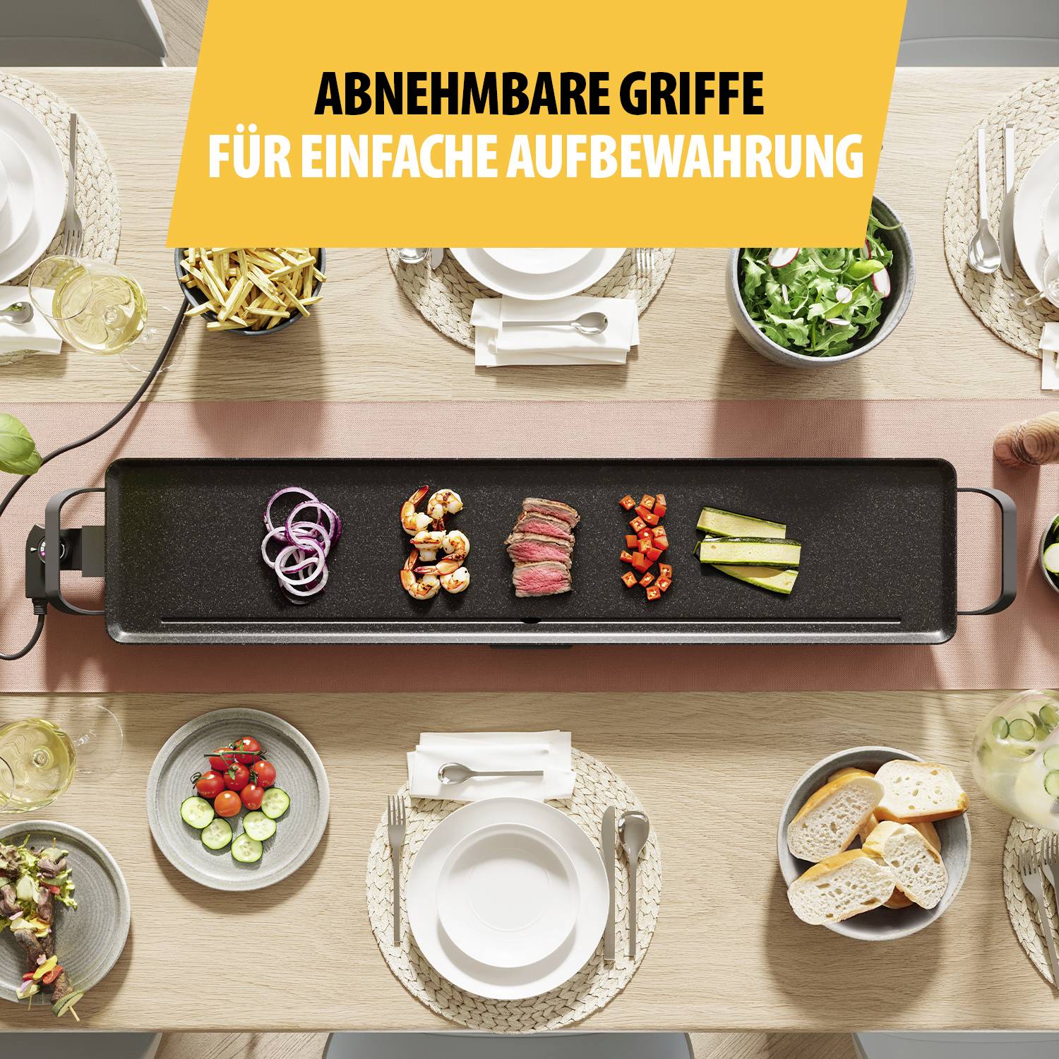 Ett bord med en grillplatta i mitten. Där ligger grönsaker och räkor. Ovanför ett banner med texten 'Avtagbara handtag för enkel förvaring'.