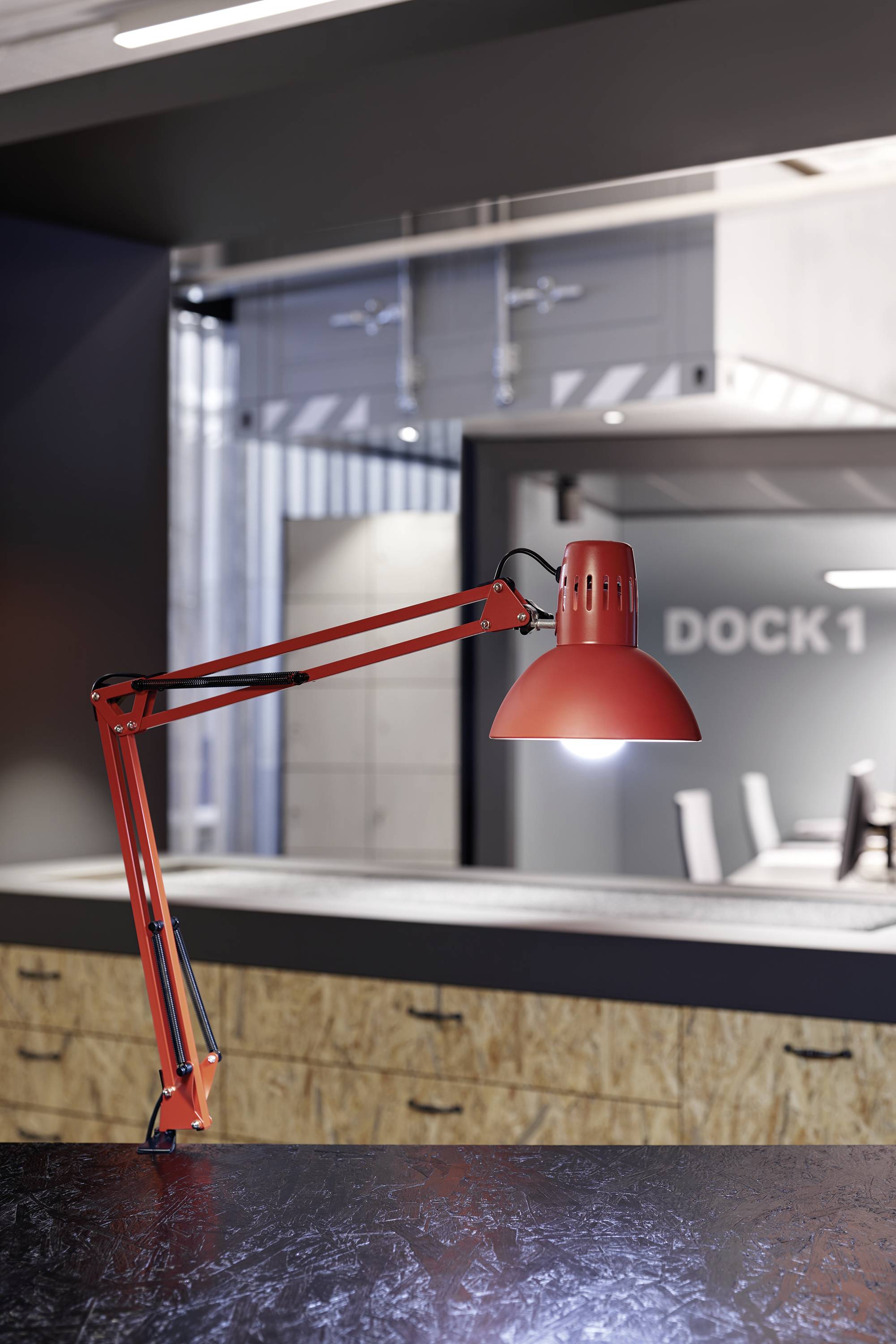 Röd bordslampa i ett modernt kontor, i bakgrunden ett konferensrum med skylten 'DOCK 1'.