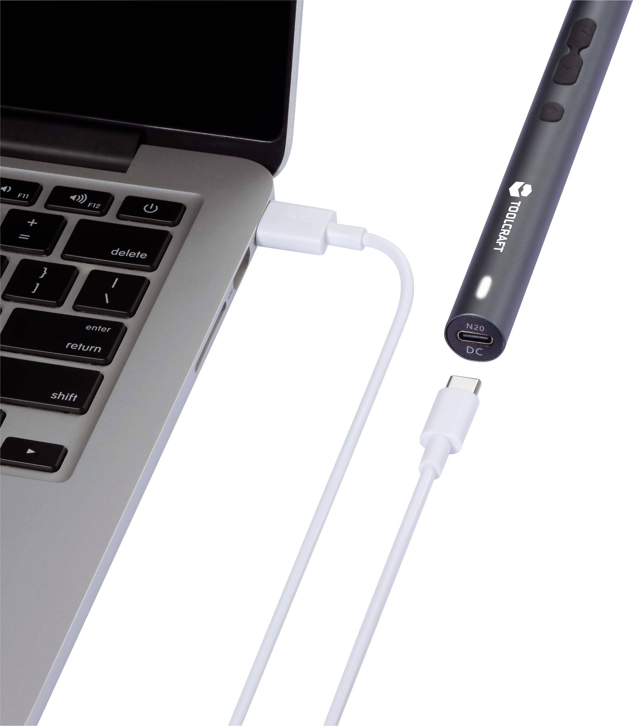 En bärbar dator med USB-port, ansluten med en USB-kabel till en tunn, avlång elektronisk enhet.
