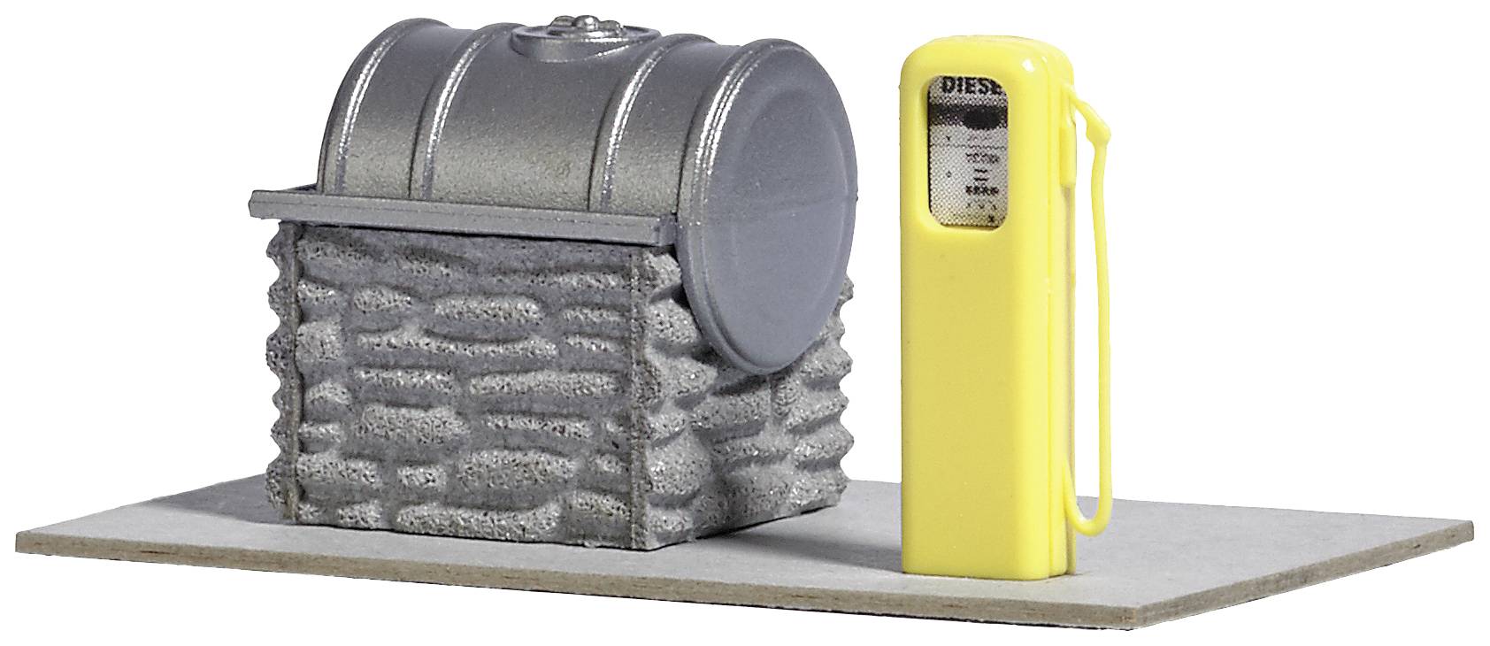 En modell av en silverfärgad oljetank bredvid en gul bränslepump på en grå bas.