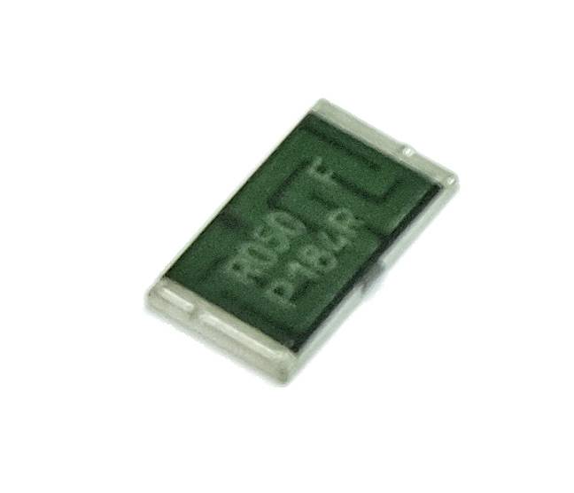En grönaktig elektrisk komponent, sannolikt ett motstånd eller en diod, med vita markeringar på ovansidan.