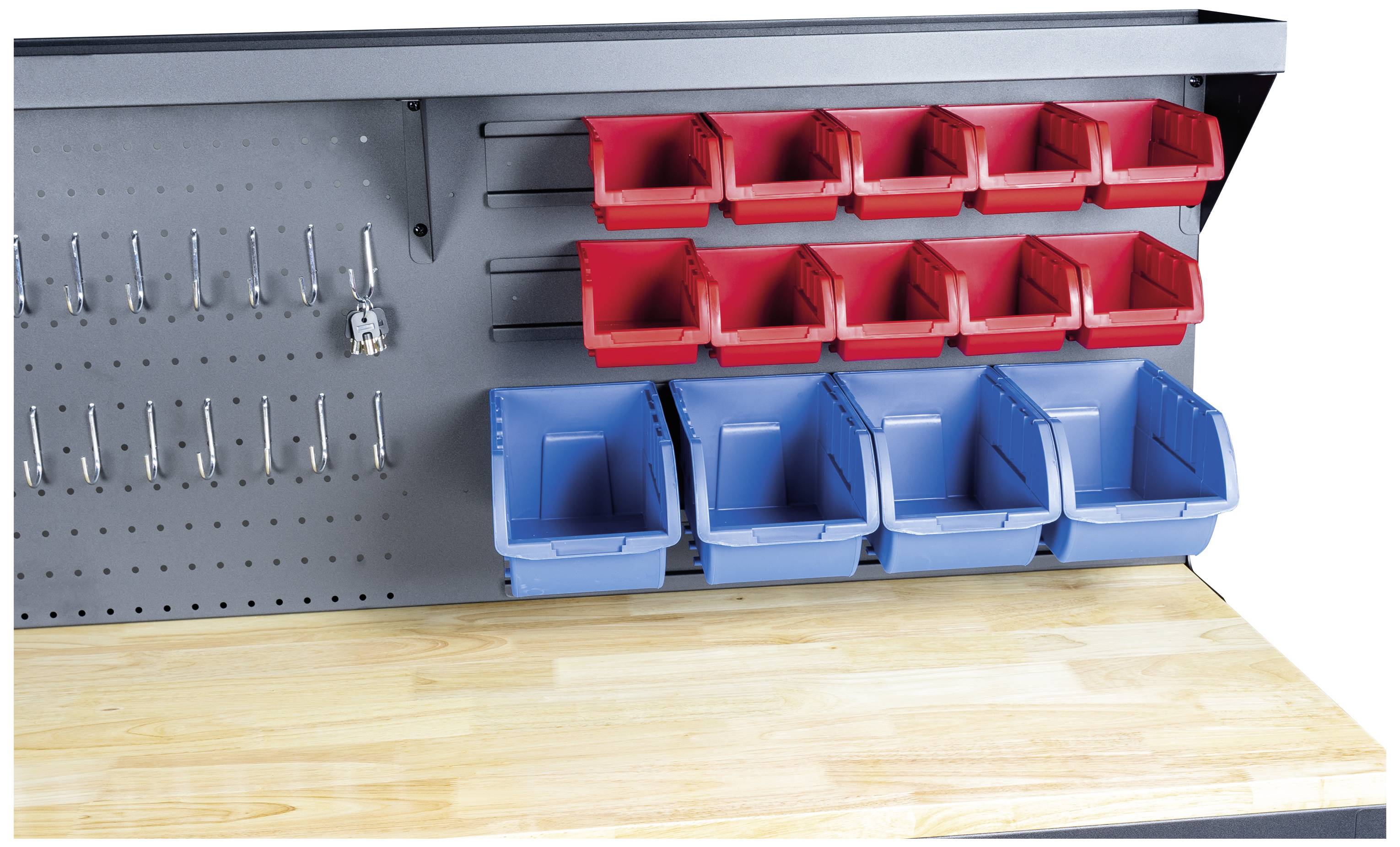 Arbetsbänk med hålvägg, röda och blå plastlådor för förvaring av verktyg. Träbordsskiva längst ner i bilden.