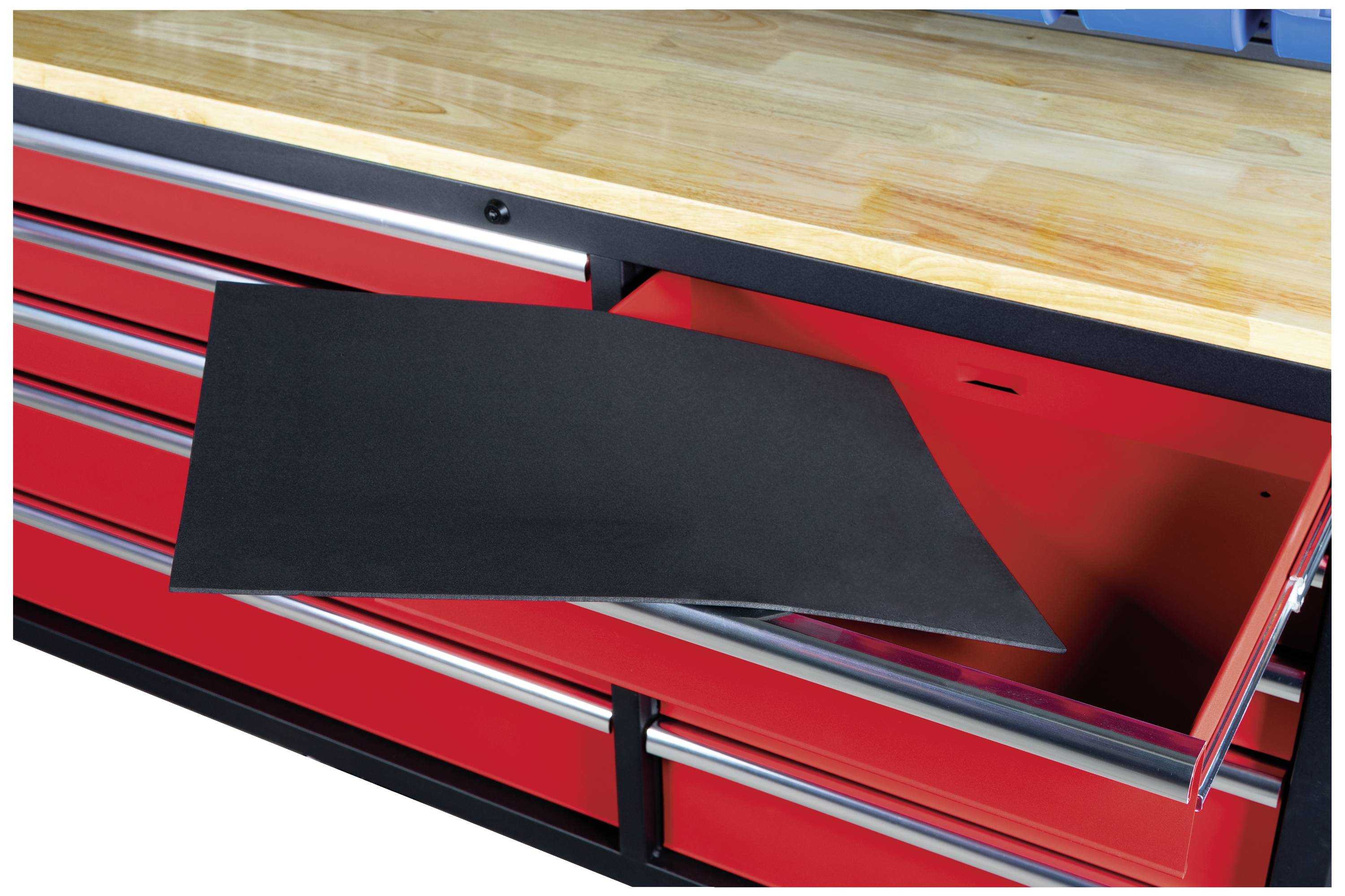 En röd arbetsbank med flera lådor, där en är öppen. En svart halkmatta är delvis utdragen ur den öppna lådan.