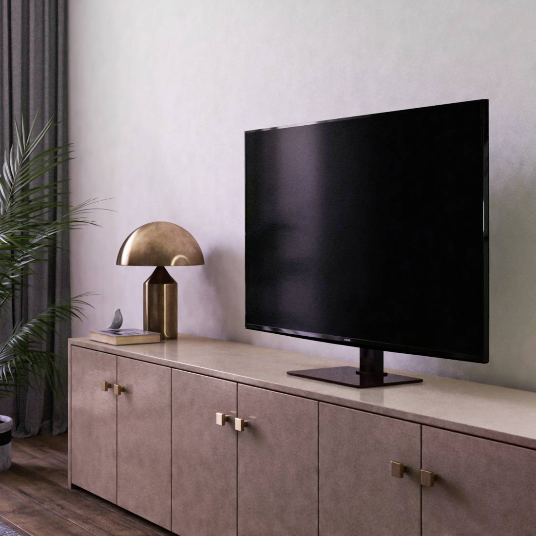 Ett modernt vardagsrum med en stor platt-TV på ett träskåp. En bordslampa till vänster och en växt till höger kompletterar inredningen.