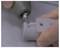 En person använder ett precisionsinstrument för att skära eller finputsa en 3D-printad detalj och visar en manuell slutbehandlingsprocess på ett föremål med hål.