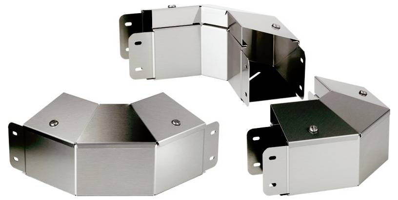 Tre metalliska hörn-kanaler i L-form, fastsatta med skruvar. De används för att täcka eller leda kablar längs kanter.
