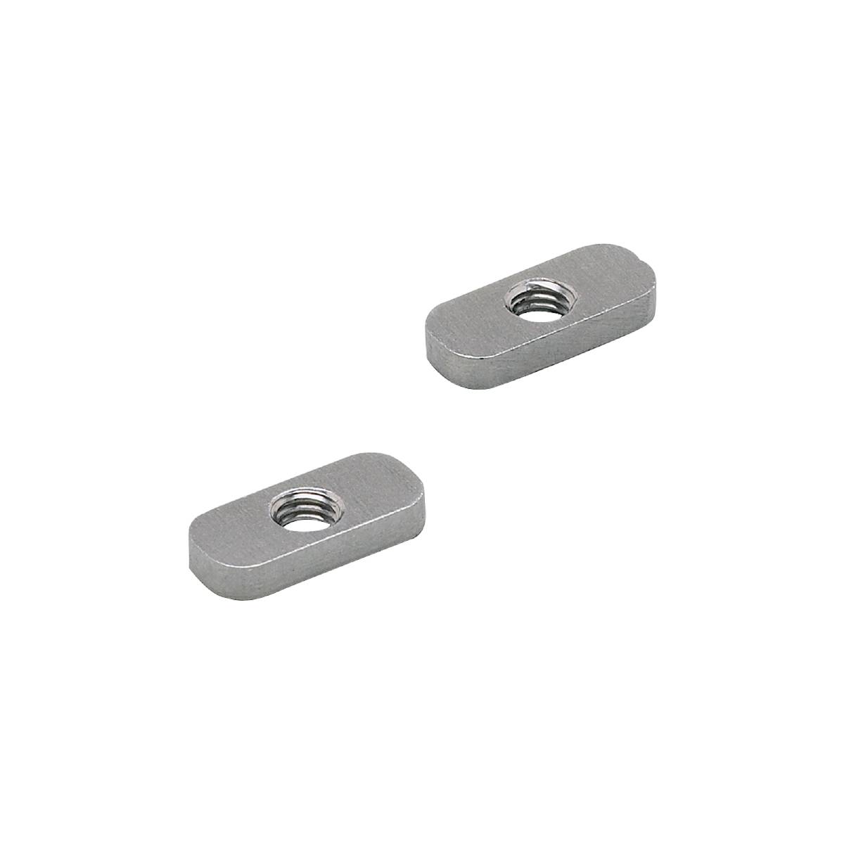 Två silvergrå, rektangulära metalldelar med ett centralt hål, framför en svart bakgrund.