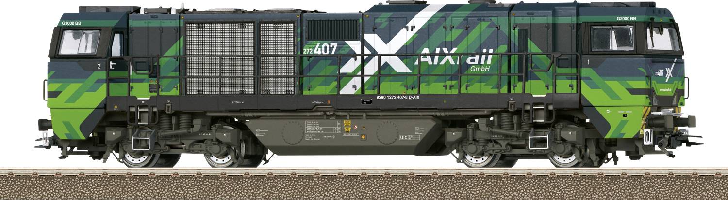 Grön och svart lokomotiv med texten 'AXArail GmbH', står på järnvägsspår. Den visar modern godstågteknik.