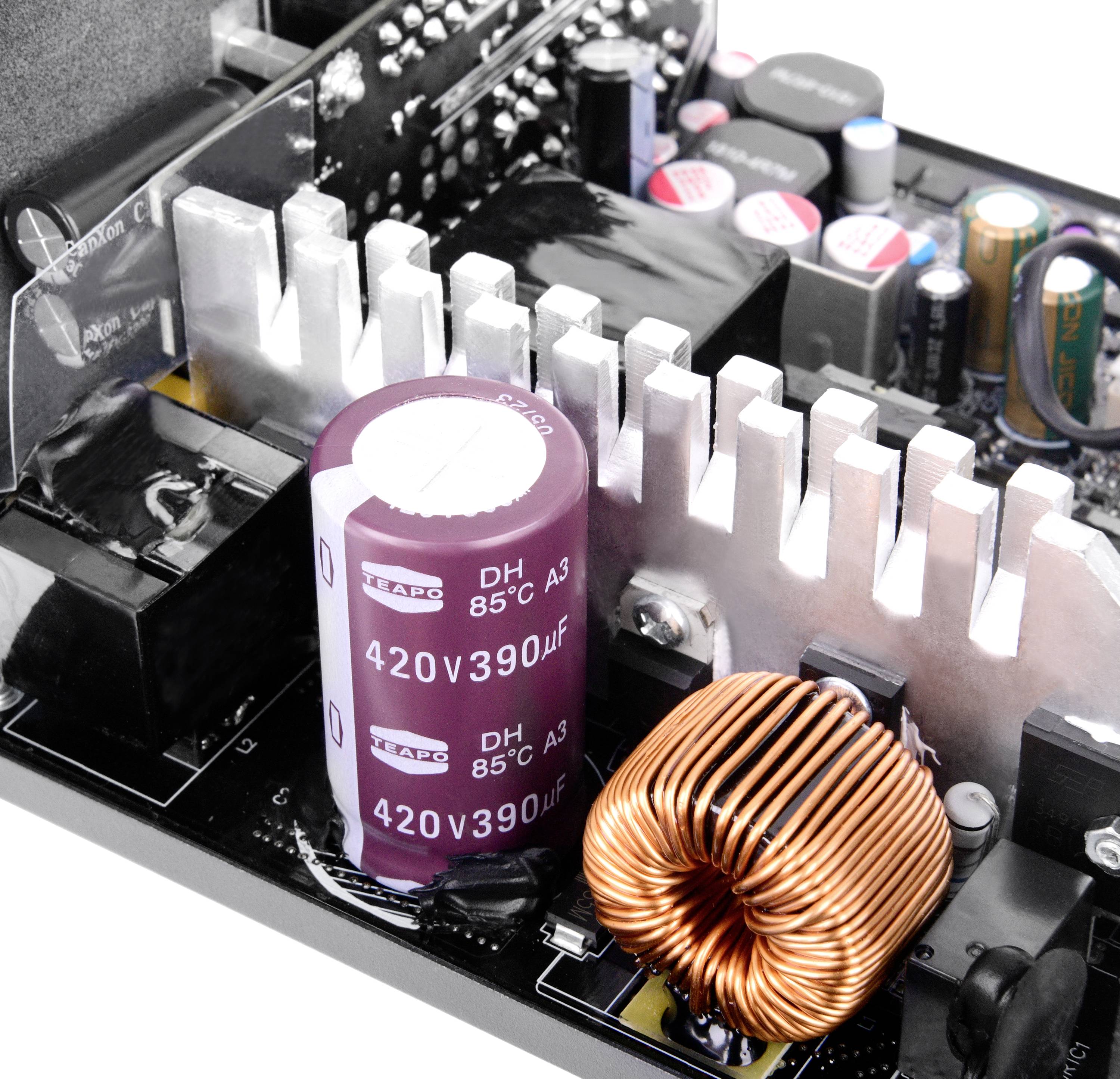 Ett datormoderkort visar detaljerat elektroniska komponenter som kondensatorer, kylflänsar och spolar, vilka är viktiga för driften.