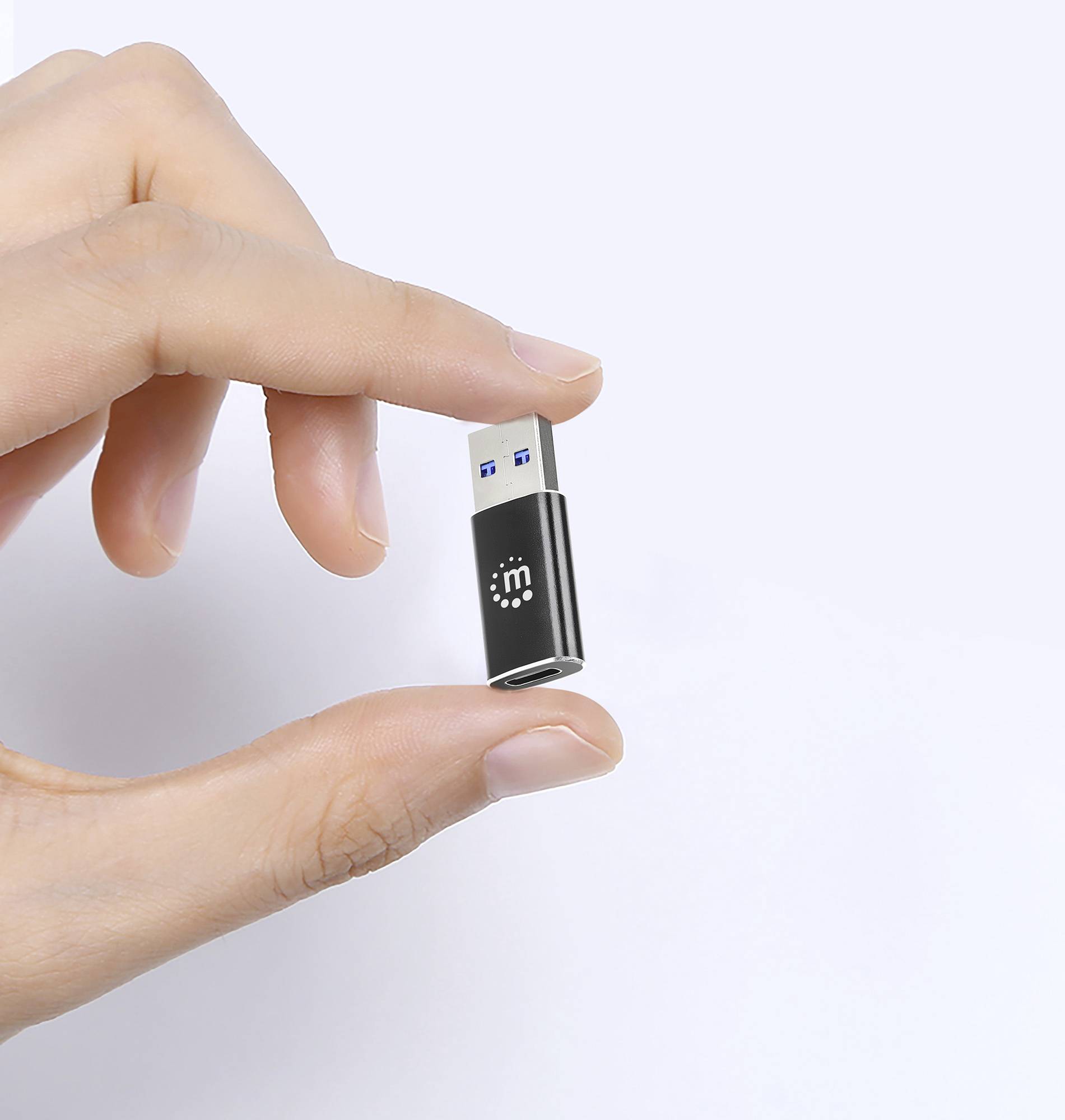 En hand håller ett litet svart USB-minne med en vit symbol på framför en vit bakgrund.