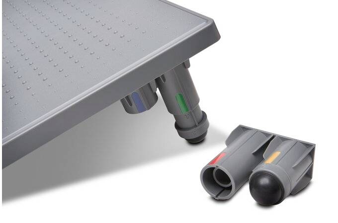 Grå rampfötter med färgkodade kontakter. En fot monterad på en platta, ytterligare en liggande separat bredvid.