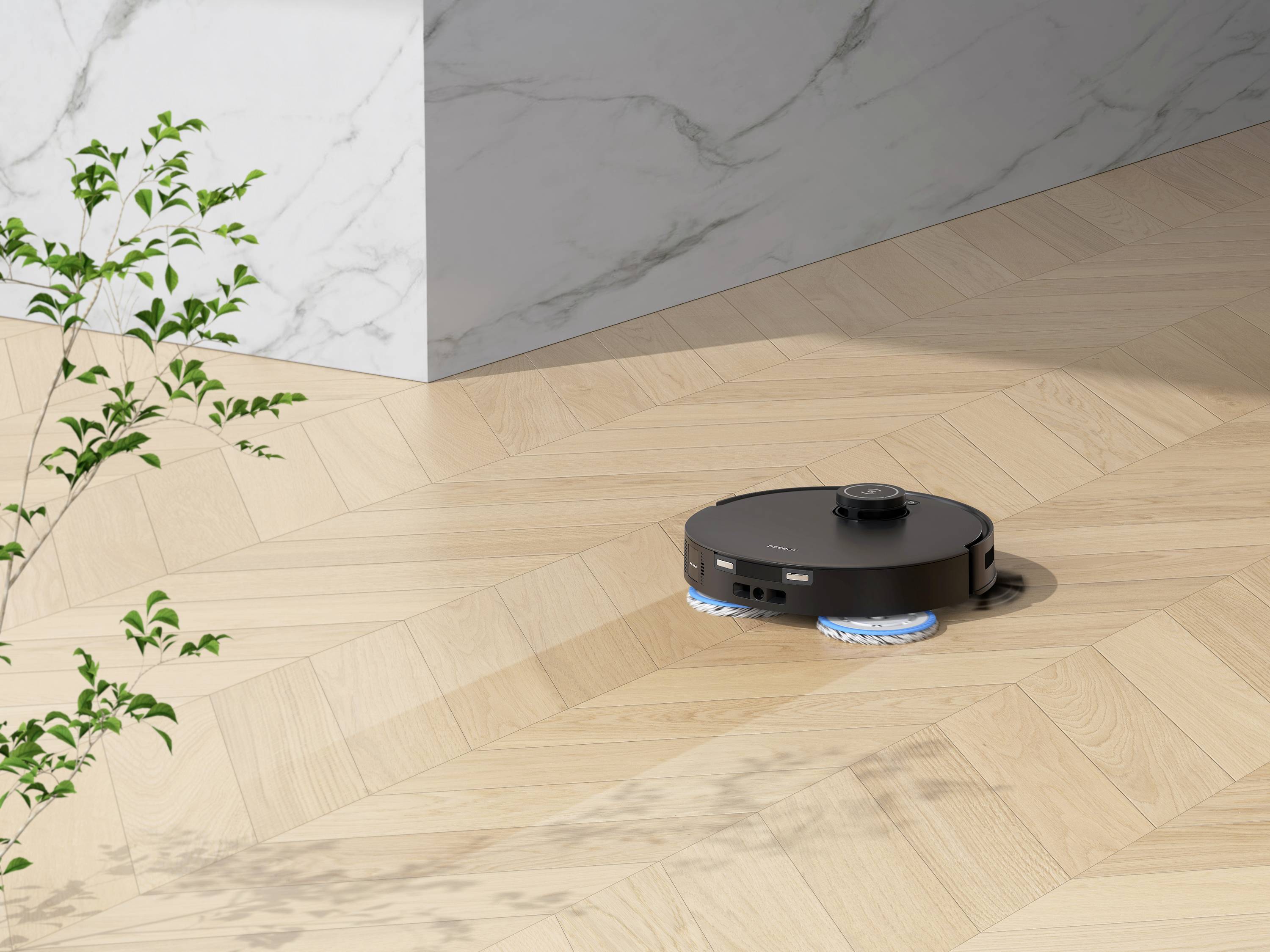 En svart robotdammsugare rengör ett trägolv bredvid en marmorvägg. En växt står i förgrunden till vänster.