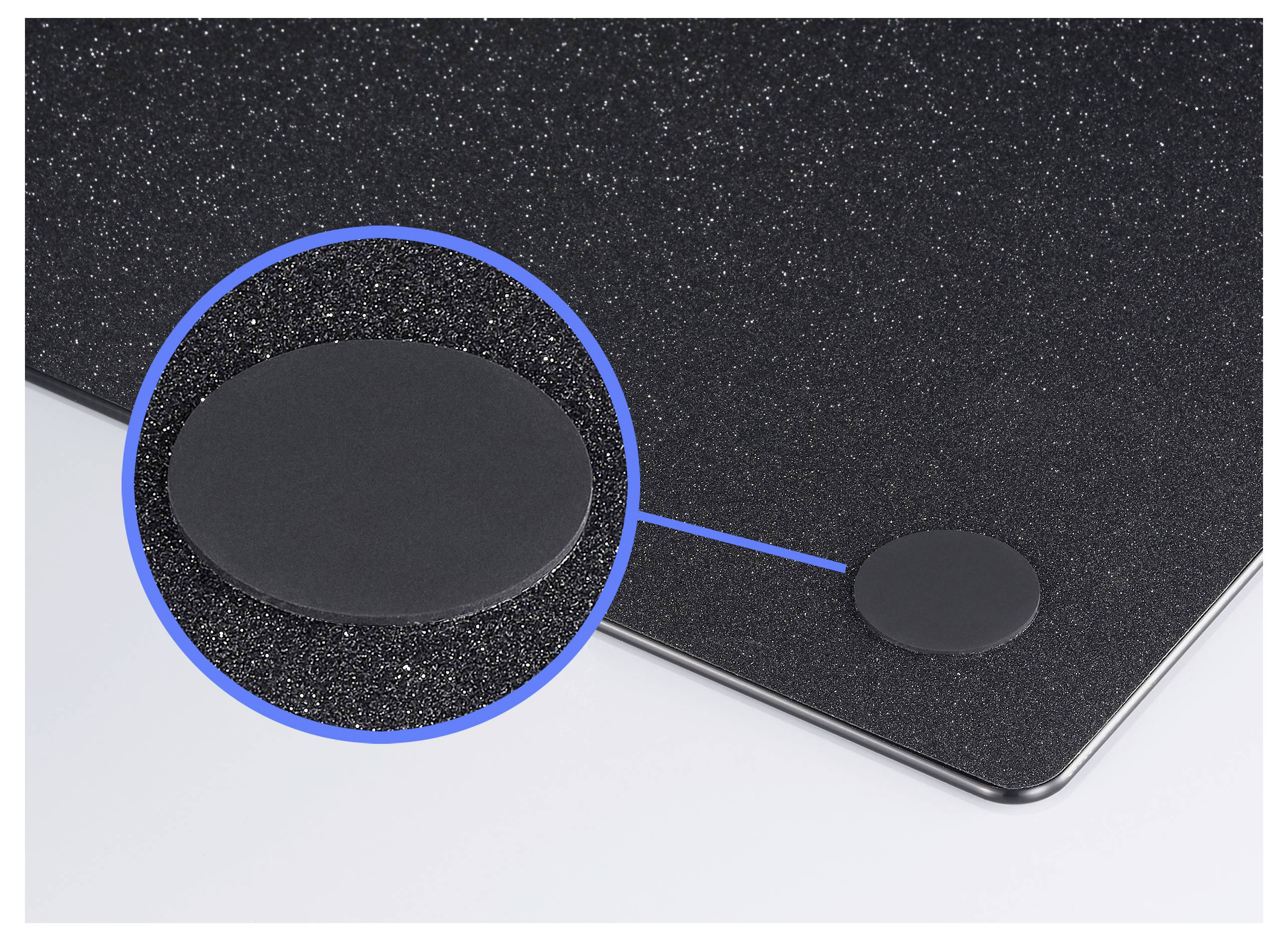 En svart, rund filtglidare är fäst på en slät yta. Ett förstoras utsnitt visar dess strukturerade textur.