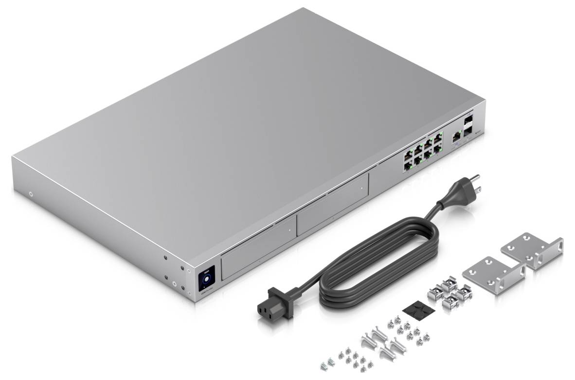 Silverfärgad nätverksswitch med flera Ethernet-portar, nätadapter, monteringsklämmor och skruvar, allt på vit bakgrund.