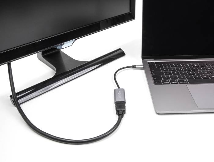 En monitor är ansluten till en bärbar dator med hjälp av en kabel som löper från skärmen till laptopens sida.
