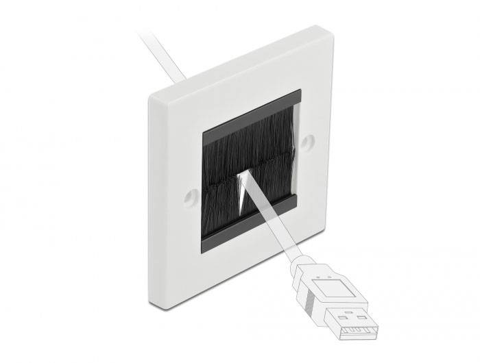 En vit kabeltätning med svarta borst, genom vilken ett USB-kabel förs. Perfekt för prydlig kabelhantering.