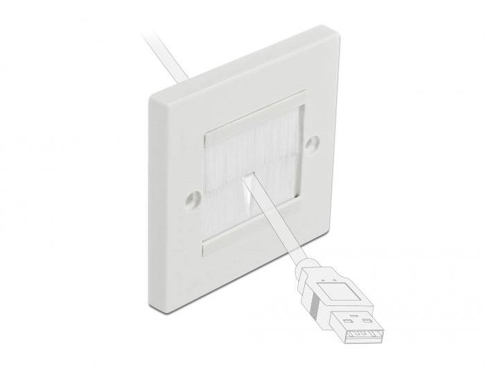 En vit kabelgenomföring i en vägg, genom vilken ett USB-kabel löper. Den visar en ordentlig kabelhantering.