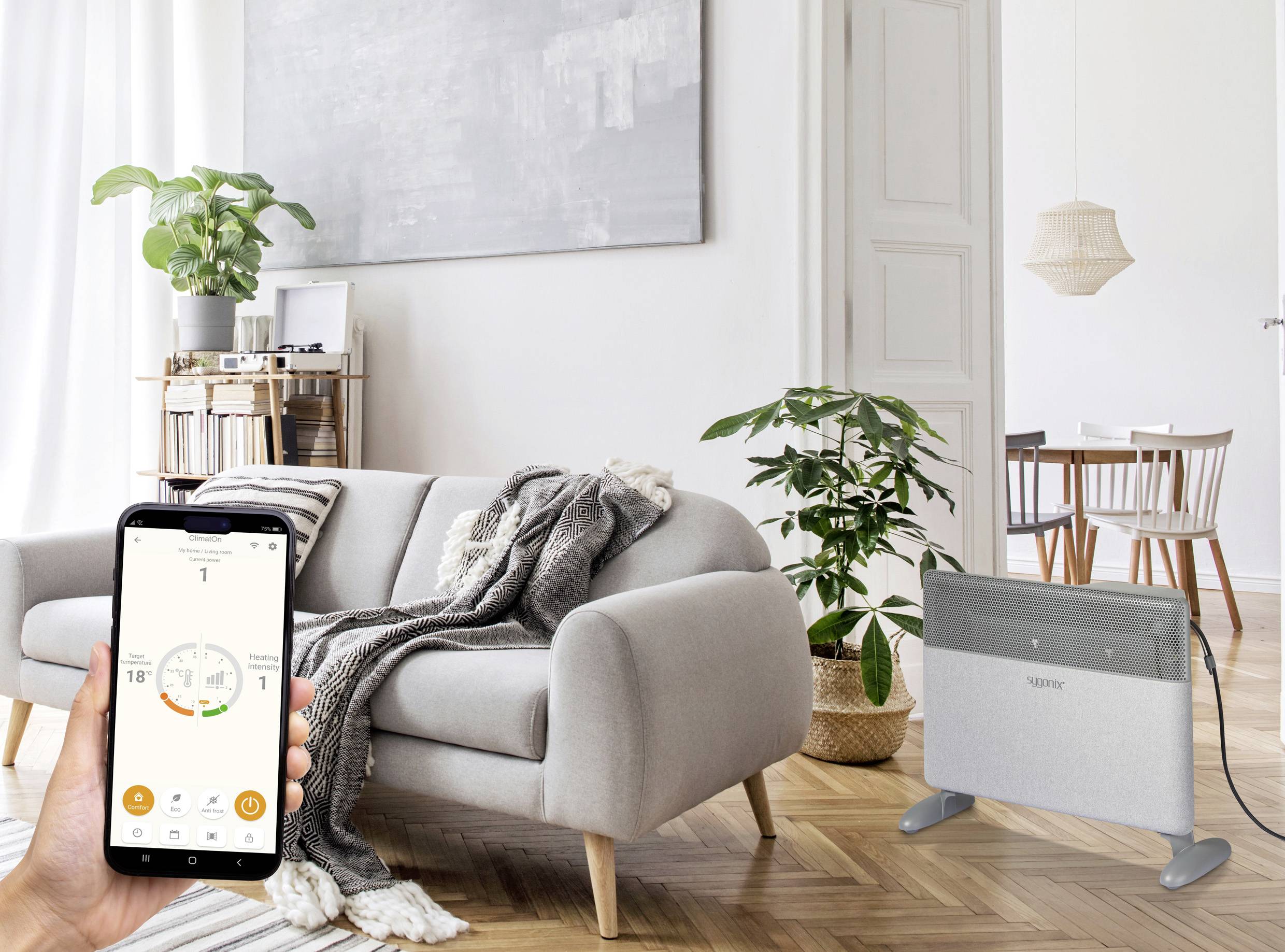 En person håller en smarttelefon som visar en värmestyrningsapp; i bakgrunden ett modernt vardagsrum med en bekväm soffa.