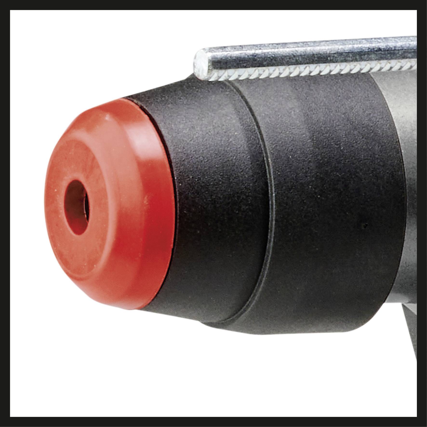 Närbild av en svart cylinder med röd lock, möjligen en del av ett verktyg eller en apparat.