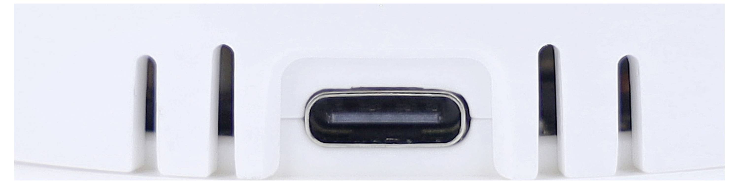 Närbild av en USB-C-port på en vit enhet, sannolikt en del av en elektronisk produkt som en laddare eller hubb.
