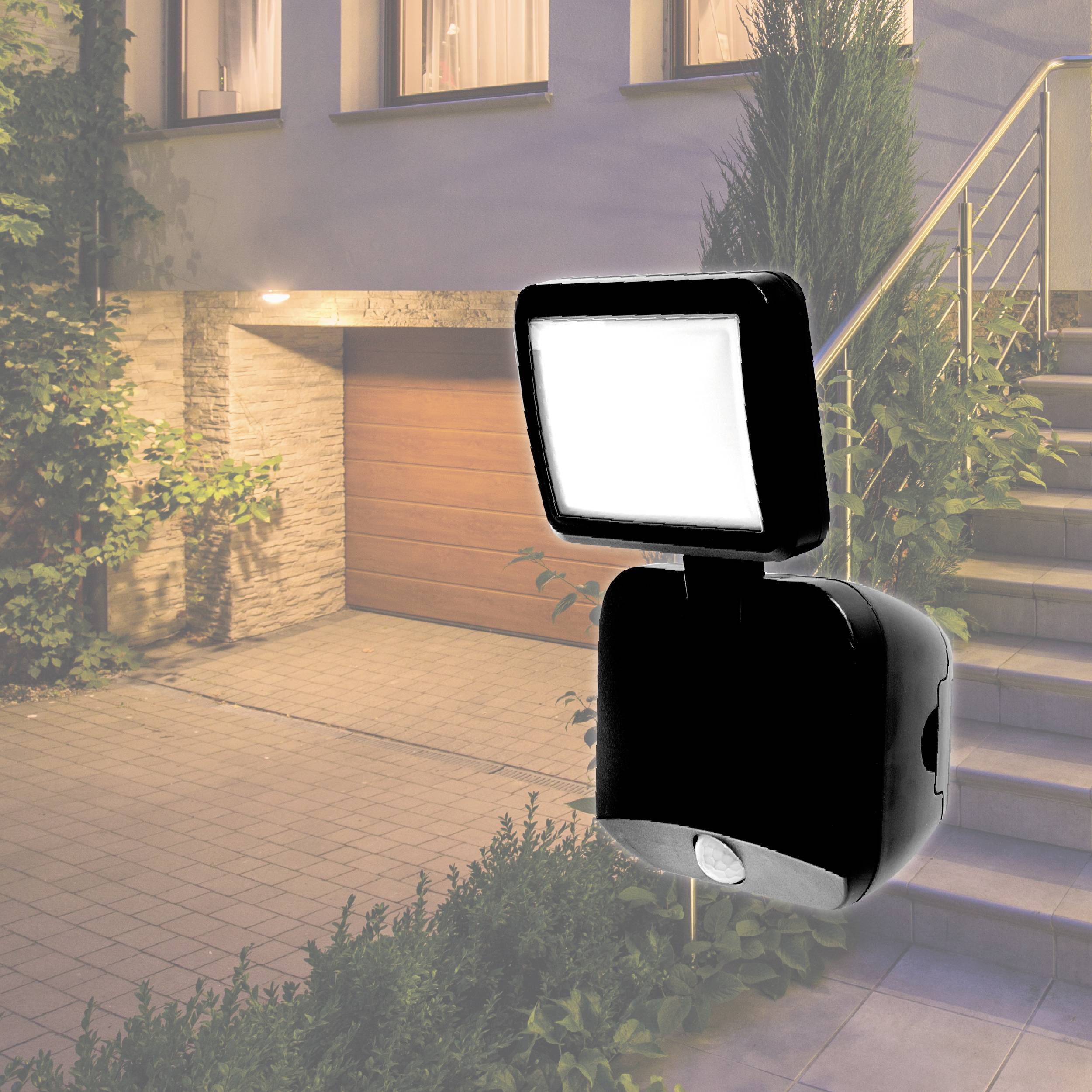 Utomhusbelysning med rörelsedetektor lyser upp en husfasad nattetid. Belysningen belyser entrézonen och en trappa.