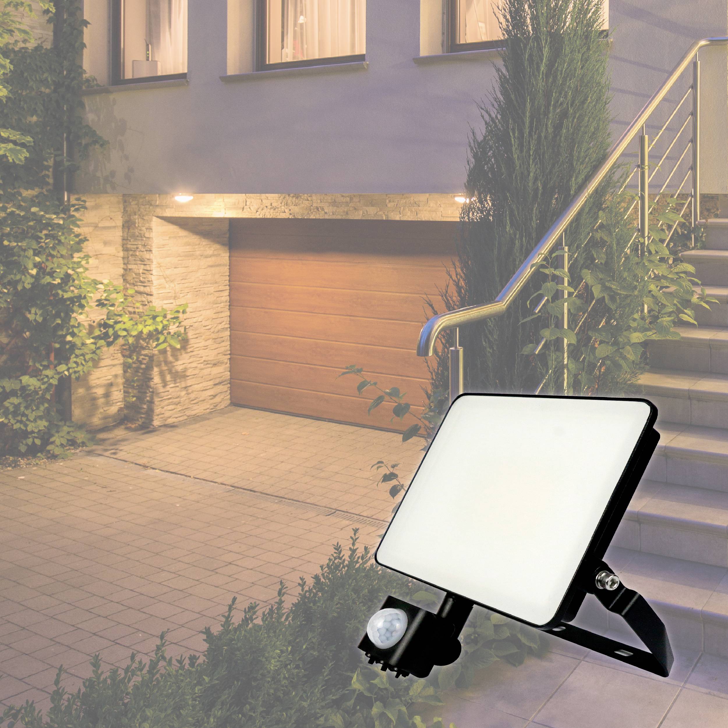 En ljus LED-strålkastare belyser en garageuppfart bredvid en trappuppgång.