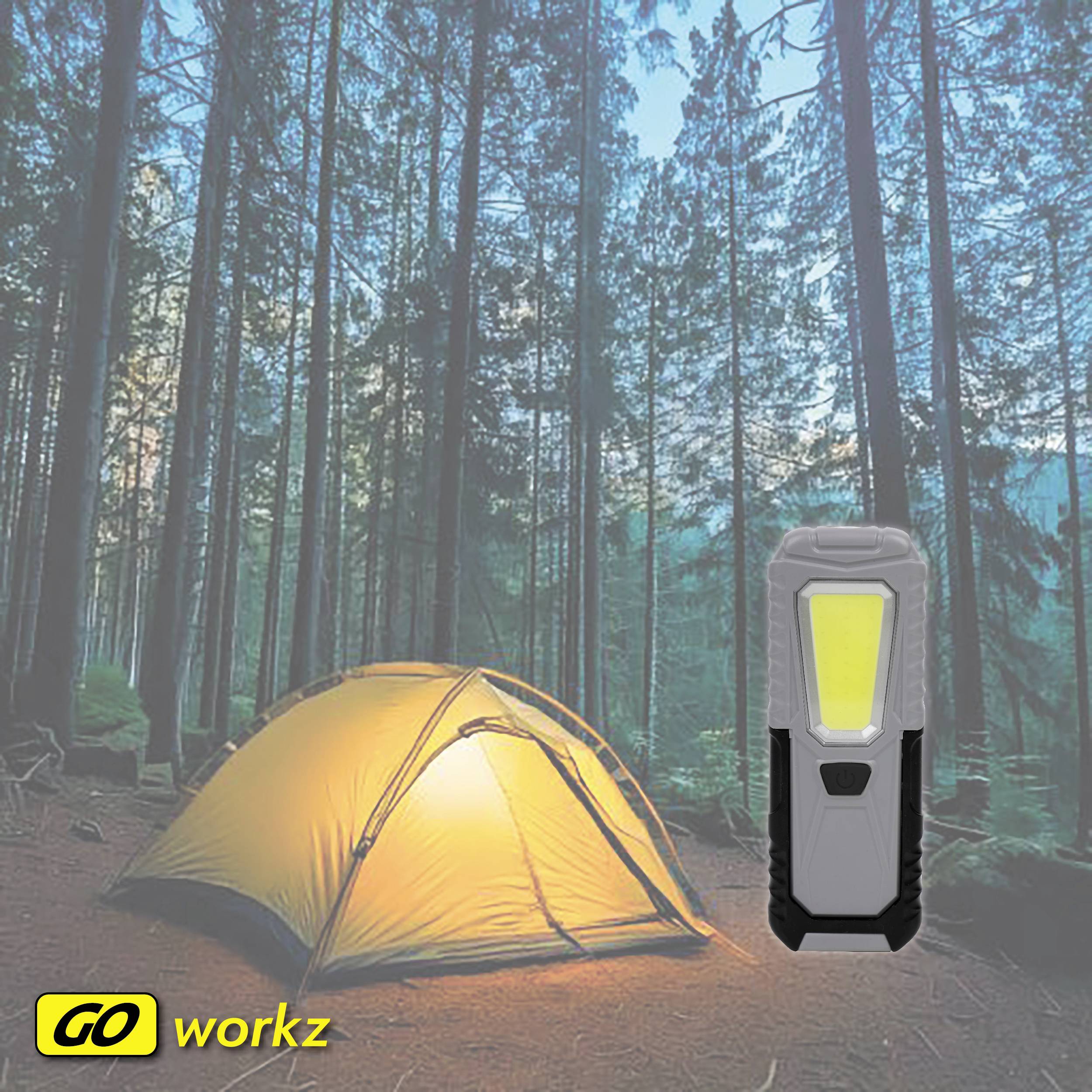 Ett tält lyser i skogen vid skymningen. En ficklampa ligger bredvid. Text 'GO workz' längst ner till vänster. Atmosfär: Äventyr och natur.