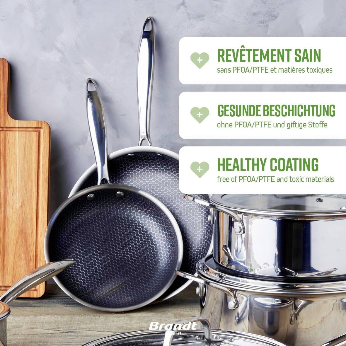 Två stekpannor och en skärbräda på ett träbord. Text på svenska: 'Hälsosam beläggning utan giftiga ämnen'.