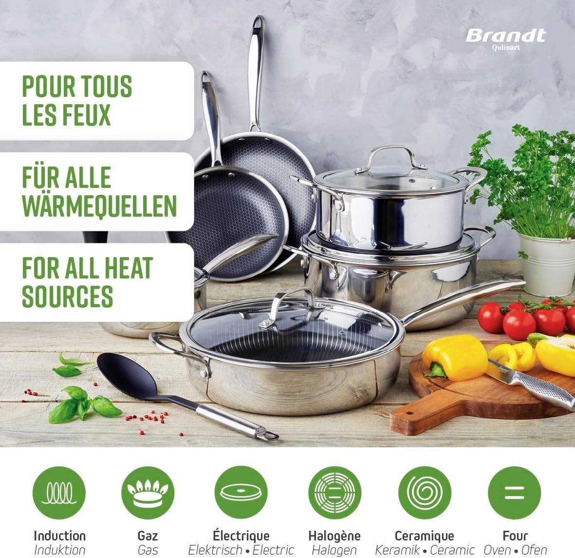 Flera rostfria stekpannor och kastruller med lock är placerade på ett bord bredvid färgglada grönsaker. Lämpliga för alla värmekällor.