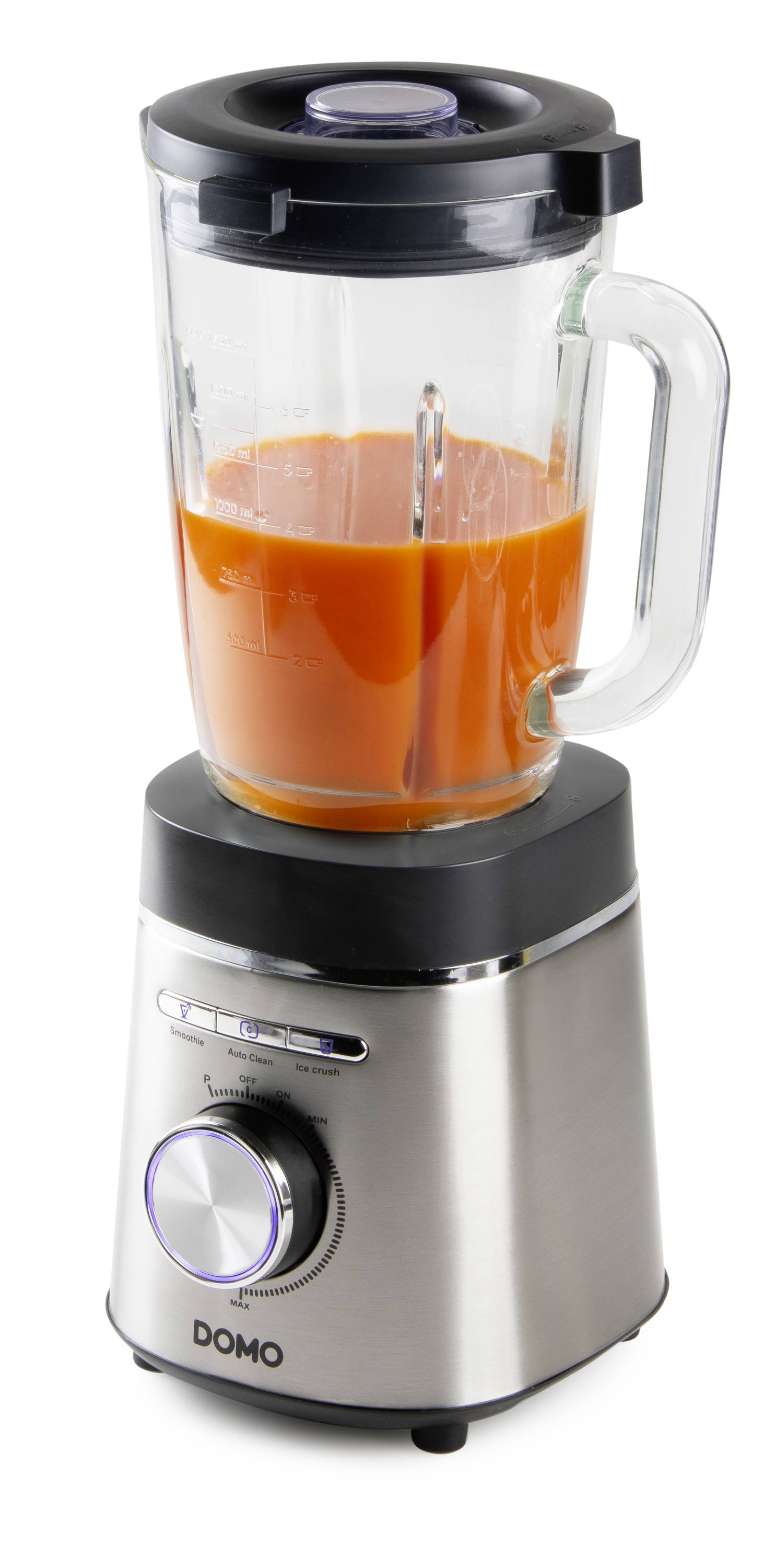 En mixer i rostfritt stål med glaskanna, fylld med orange vätska, står upprätt.