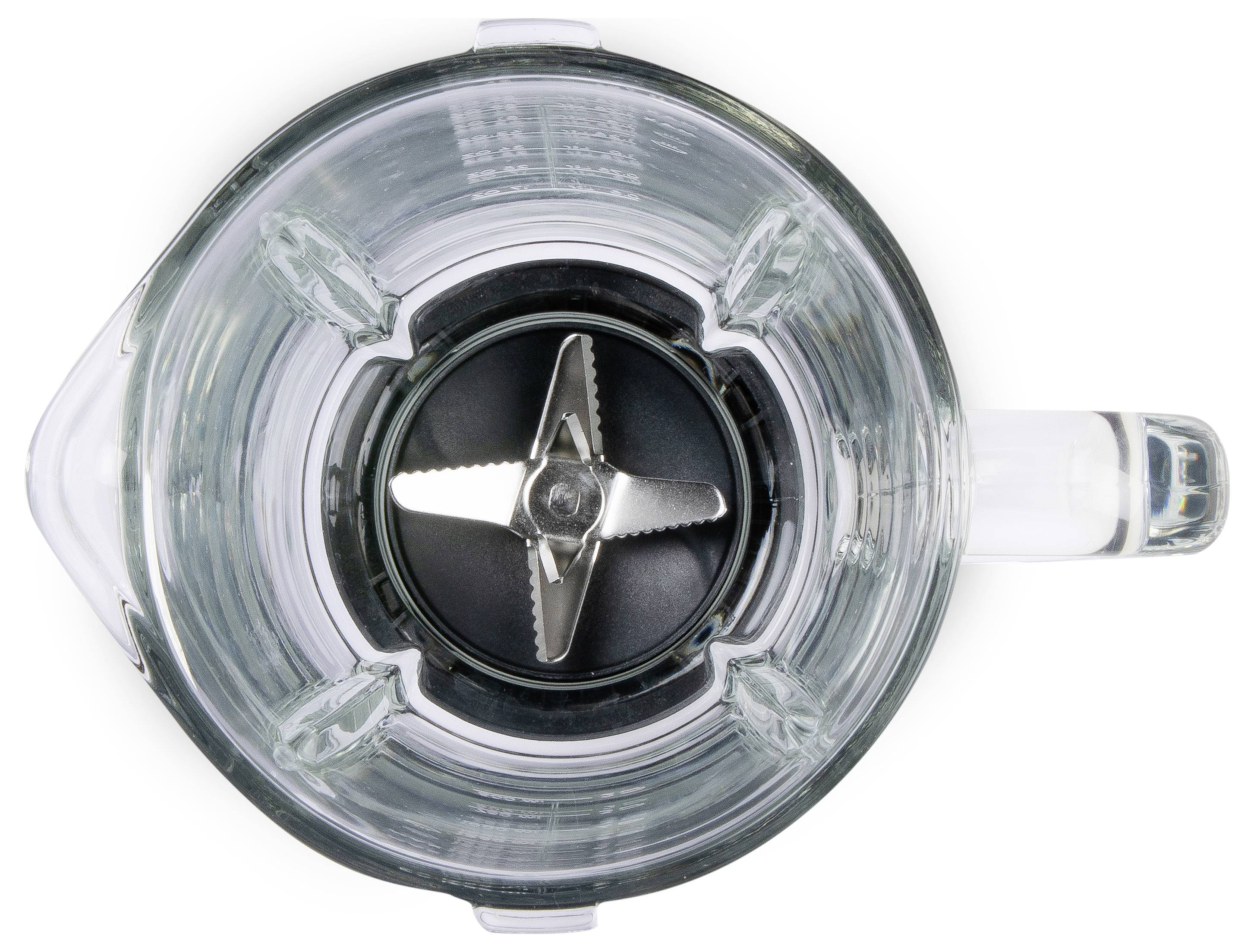 En tom, genomskinlig mixerskål sedd ovanifrån med en synlig metallkniv i mitten.