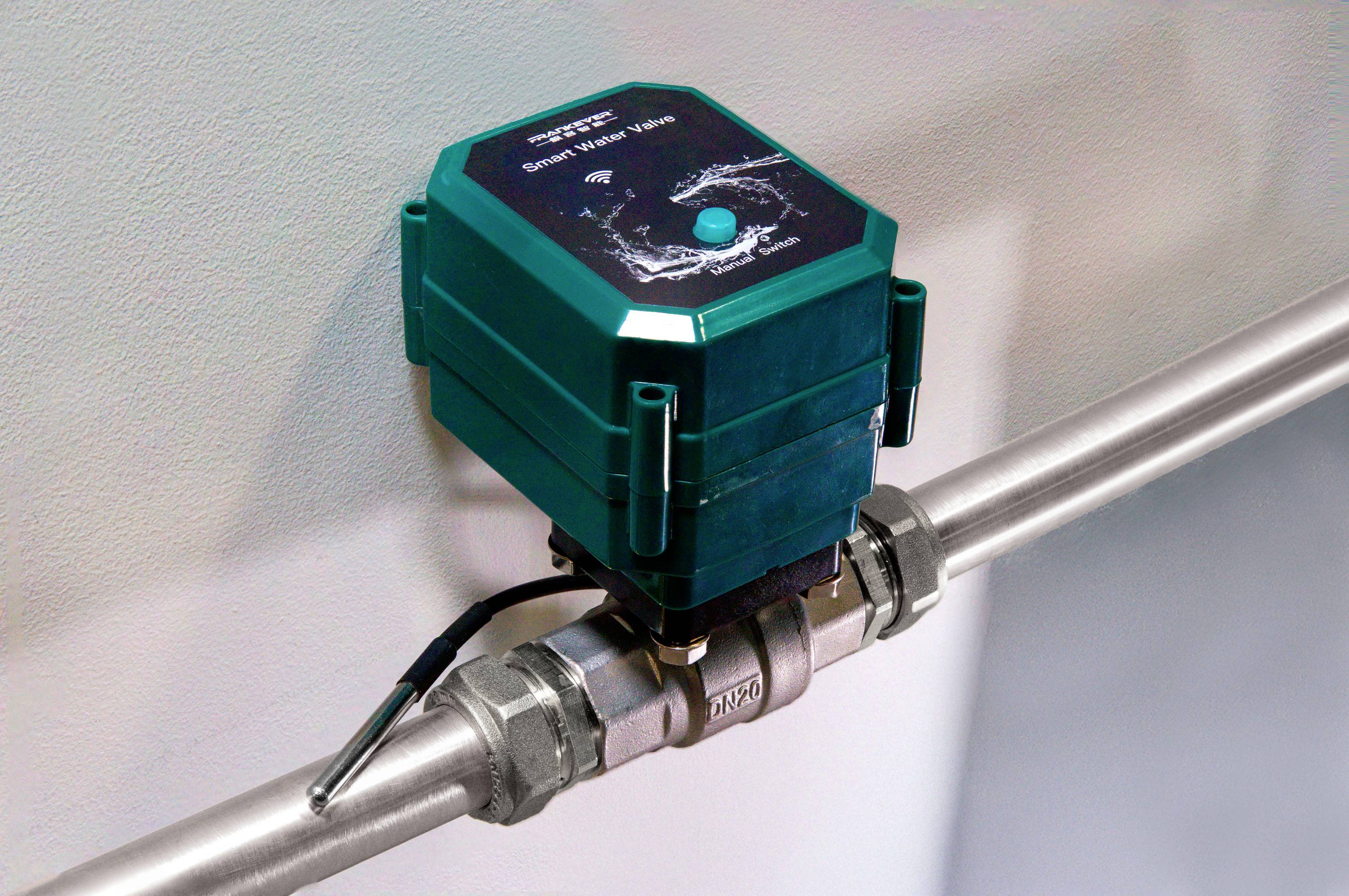 En grön smart vattenmätare är installerad på ett metallrör. Den mäter vattenförbrukningen digitalt.