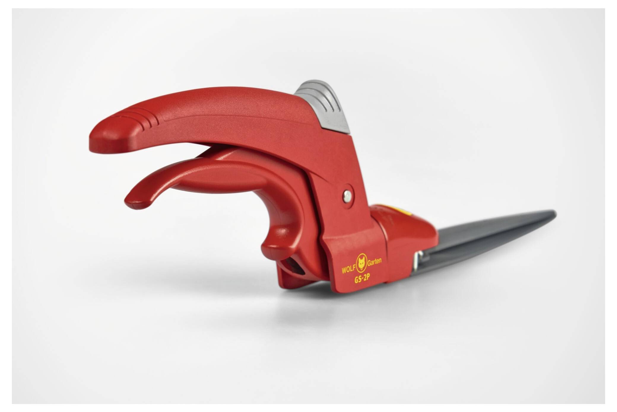 Manuell gräsklippare i rött, med ergonomiskt handtag och svart klinga, perfekt för precisionsklippning av gräskanter.