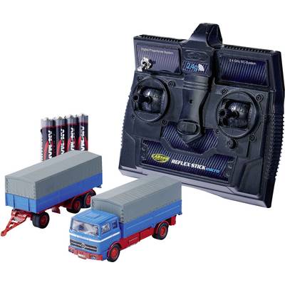 Fjärrstyrd med två joystickar och LCD-display; leksaks-lastbil med tillhörande trailer, båda i blått med grå höljen; fyra AA-batterier.