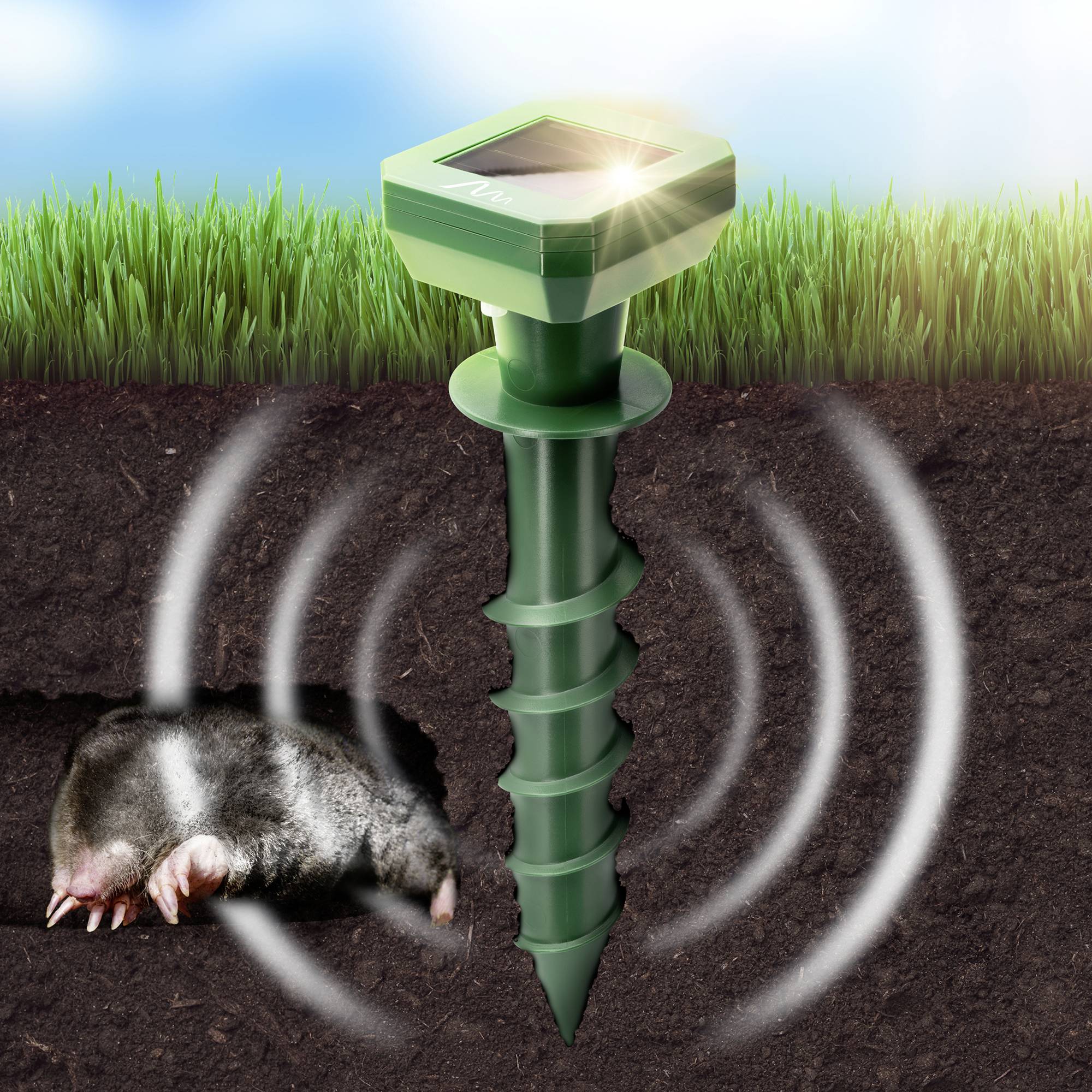 En mullvad i jorden bredvid en ultraljudsbaserad skadedjursbekämpare, omgiven av gräs. Skadedjursbekämparen sänder ut vibrationer.