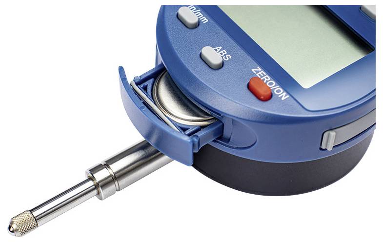 Ett digitalt mätinstrument med en metallisk givare, knappar märkta 'På/Av', 'ABS' och 'Noll'. Ett batteri är delvis utkastat.