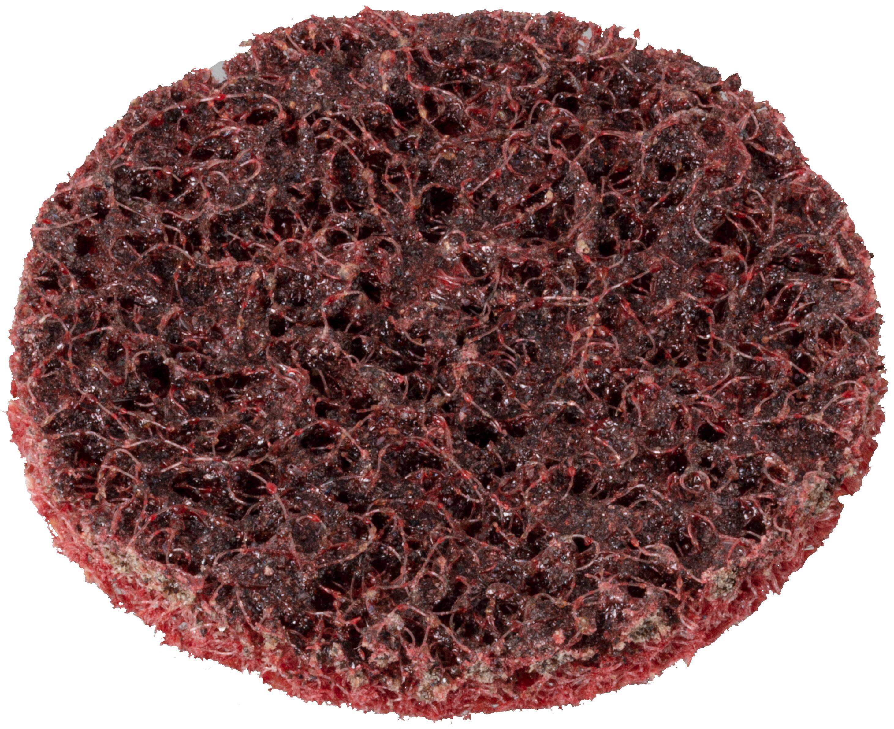 Ett runt, slipande rött skurblock med grov textur, vanligtvis använt för rengöring av ytor.