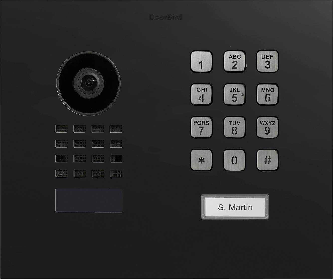 En svart dörrtelefon med ett kameralins, ett nummer-tangentbord och en namnplatta märkt S. Martin.