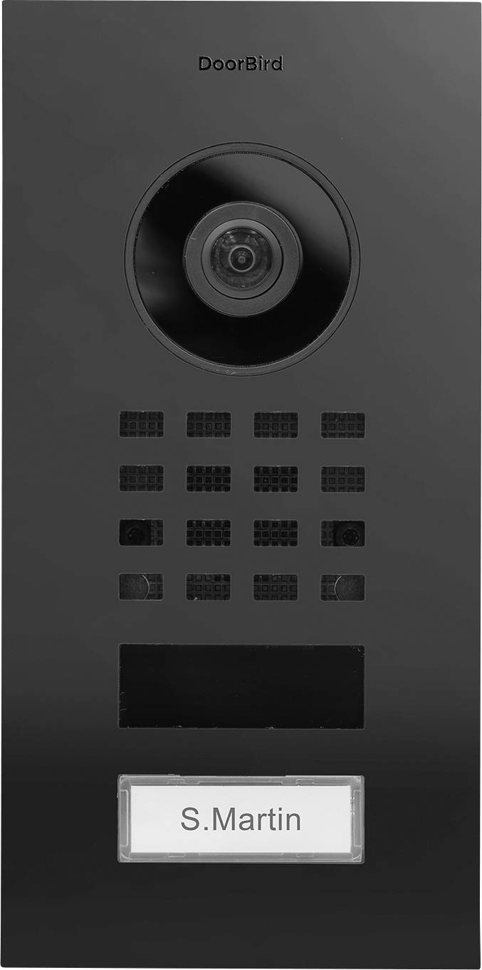 En svart DoorBird-porttelefon har ett kameralinsperspektiv överst och en namnplatta längst ner som visar 'S. Martin'.