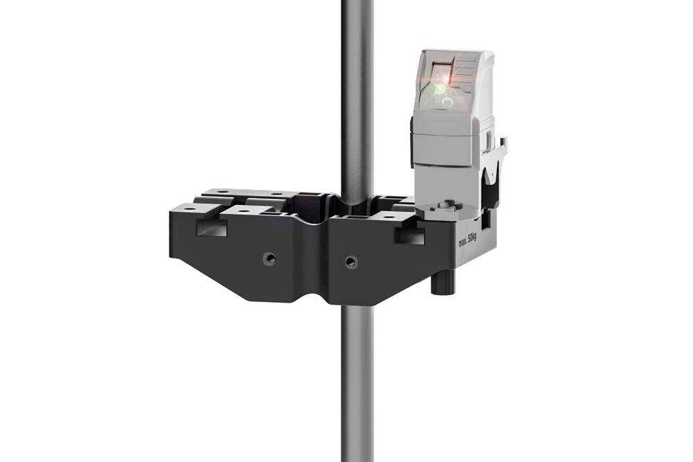 Ett svart och silver justeringsverktyg fäst vid en vertikal metallstång, utrustad med en digital skärm som visar en grön bock, vilket indikerar korrekt justering.