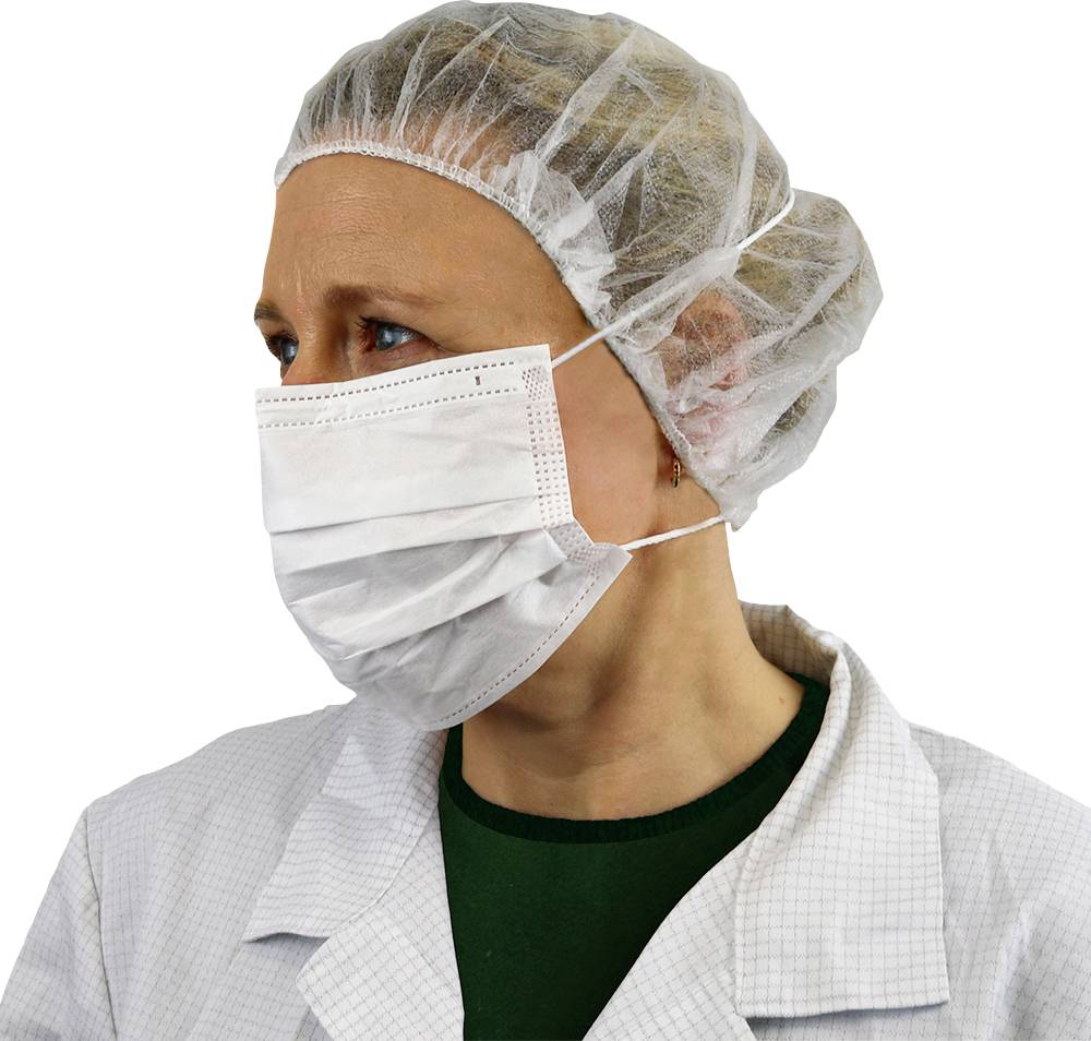 En vårdarbetare som bär en vit kirurgisk mask, hårnät och laboratorierock, vänd något åt höger, ser alert och professionell ut.