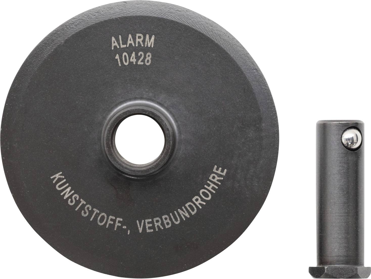 "LARM 10428" är ingraverat på en mörk, cirkelformad skiva med ett hål i centrum. Bredvid den finns en liten cylindrisk metallbit.