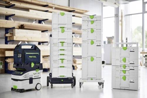 Staplade Festool förvarings- och transportsystem i en verkstad, som visar olika storlekar och konfigurationer på hjul.