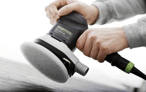Händer som använder en Festool slipmaskin på en yta och demonstrerar hantering och funktion av verktyget.