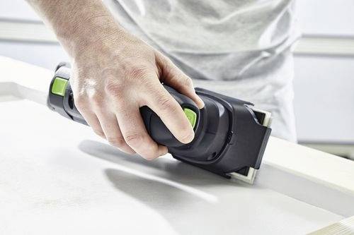 En person använder en sladdlös elektrisk slip på en träyta och fokuserar på att jämna ut och avsluta materialet.