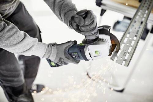 En person som bär handskar använder en vinkelslip för att skära genom en metallbalk, med synliga gnistor som flyger under skärprocessen.