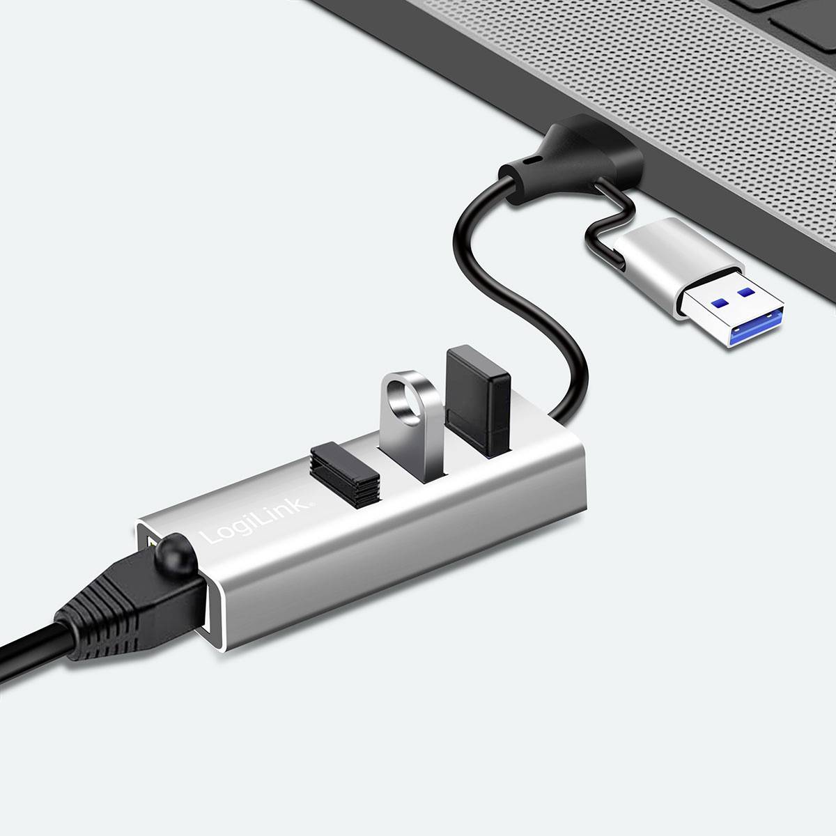 USB-hubb ansluten till en bärbar dator med flera anslutna enheter: en Ethernet-kabel, ett microSD-kort och ett USB-minne.