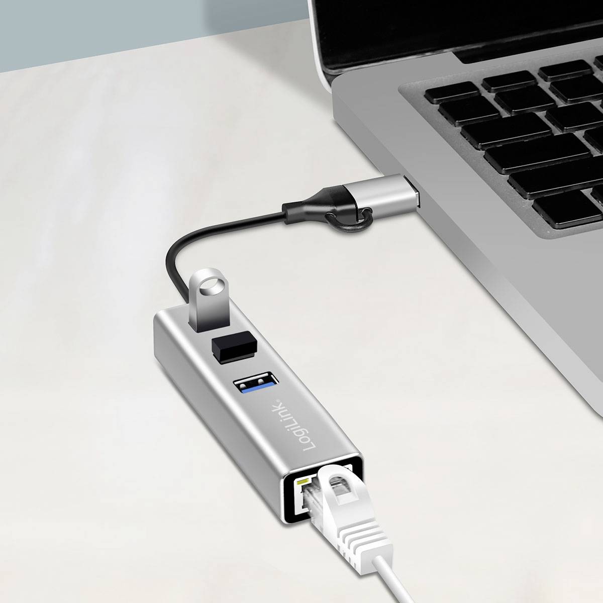 En bärbar dator med en ansluten USB-hubb som har flera portar, inklusive USB, Ethernet och HDMI, som visar olika anslutningsalternativ.